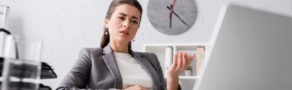 Mulher de negócios grávida descontente gesticulando durante videochamada no laptop, banner — Fotografia de Stock