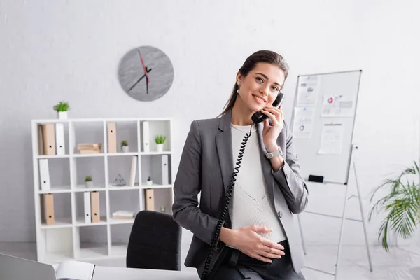 Heureuse femme d'affaires enceinte parlant sur le téléphone rétro — Photo de stock