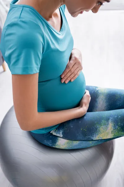 Fröhliche schwangere Sportlerin trainiert auf Fitnessball — Stockfoto