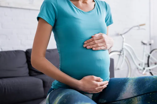 Vista parziale della sportiva incinta che si esercita sulla palla fitness — Foto stock