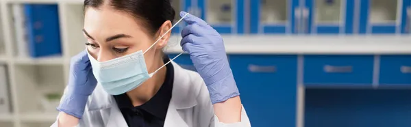 Científico en guantes de látex con máscara médica en el laboratorio, pancarta - foto de stock