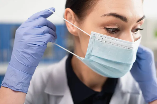 Científico morena en guantes de látex con máscara médica - foto de stock