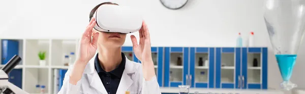 Wissenschaftler mit vr-Headset in der Nähe von Mikroskop und Kolben im Labor, Banner — Stockfoto