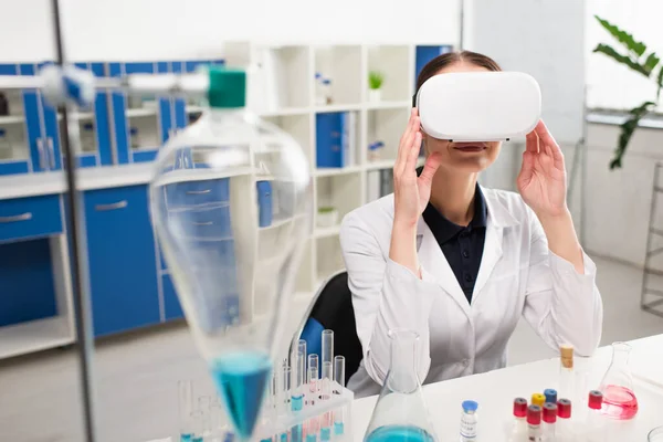 Scientist using vr headset near medical equipment and flasks in laboratory — Stock Photo