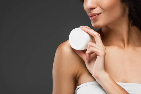 Cropped view of african american woman in white top holding cosmetic cream isolated on grey — Stock Photo