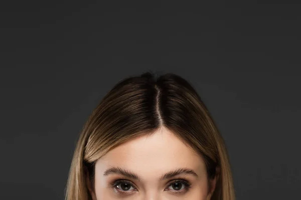 Обрізаний вид на молоду жінку з натуральним макіяжем, дивлячись на камеру ізольовано на сірому — стокове фото