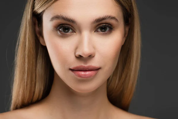 Retrato de mujer joven con maquillaje natural y piel perfecta aislada en gris - foto de stock