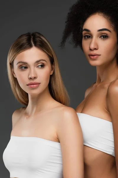Young multicultural women with perfect skin posing isolated on grey — Stock Photo