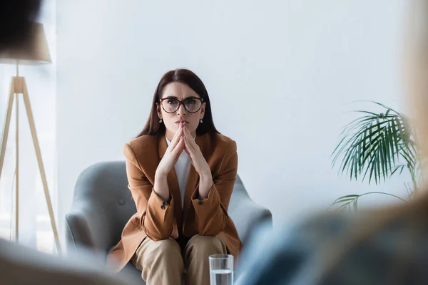 Psicologo in poltrona che ascolta pazienti offuscati durante la consultazione — Foto stock