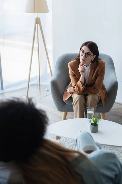 Attentive psychologist listening to blurred same sex couple in consulting room — Stock Photo