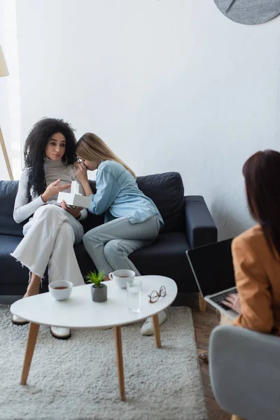 Africaine américaine femme pointant vers déprimé lesbienne copine lors de la consultation avec psychologue — Photo de stock