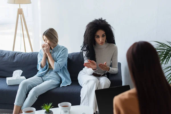 African american lesbian woman talking to blurred psychologist near crying friend — Stock Photo