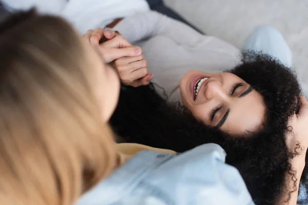 Hochwinkelaufnahme glücklicher afrikanisch-amerikanischer Frau, die Hände mit verschwommener lesbischer Freundin hält — Stockfoto