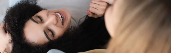 Overhead view of african american woman smiling with closed eyes near lesbian girlfriend, banner — Stock Photo