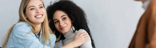 Happy interracial lesbian women embracing during psychological consultation, banner — Stock Photo