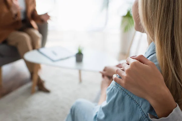 Vue recadrée de femme étreignant épaule de lesbienne copine pendant rendez-vous avec psychologue — Photo de stock