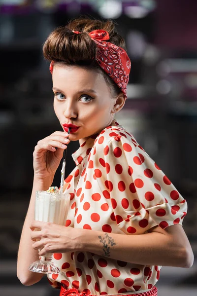 Young pin up woman drinking milkshake in cafe — Stock Photo