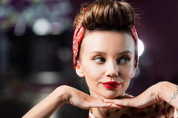 Tattooed young pin up woman with red lips looking away — Stock Photo