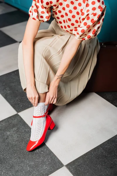 Cropped view of tattooed pin up woman adjusting white sock — Stock Photo