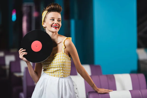 Glückliche Pin-up-Frau mit roten Lippen, die eine Retro-Platte hält — Stockfoto