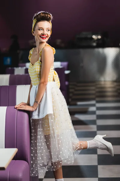 Longitud completa de bastante pin up mujer sonriendo en la cafetería - foto de stock