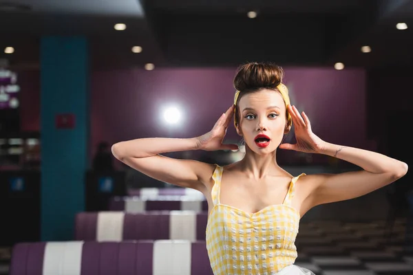 Shocked pin up woman with retro hairstyle looking at camera — Stock Photo