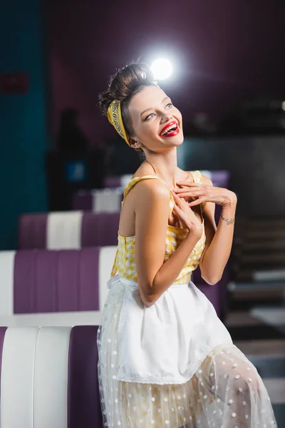 Cheerful pin up woman laughing in vintage cafe — Stock Photo