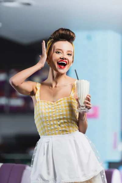 Erstaunte Pin-up-Frau mit Tätowierung mit Milchshake — Stockfoto