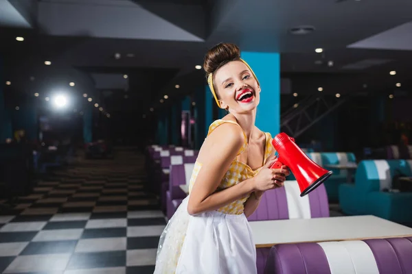 Glückliche Pin-up-Frau mit Megafon im Café — Stockfoto