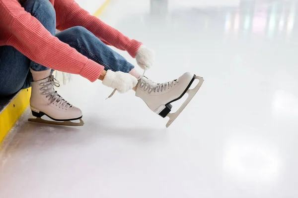 Vista parziale di giovane donna allacciatura lacci scarpa su pattini da ghiaccio — Foto stock