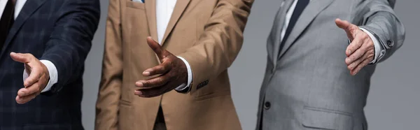 Partial view of senior businessmen standing with outstretched hands isolated on grey, banner — Stock Photo