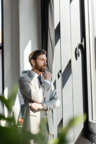 Pensive businessman looking at window in office — Stock Photo