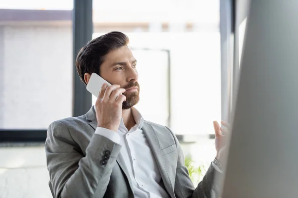 Empresário em desgaste formal falando no smartphone no escritório — Fotografia de Stock