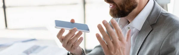 Vista ritagliata di un uomo d'affari che registra messaggi vocali su smartphone con schermo vuoto, banner — Foto stock