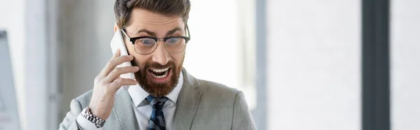 Emocionado hombre de negocios hablando por teléfono móvil en la oficina, pancarta - foto de stock