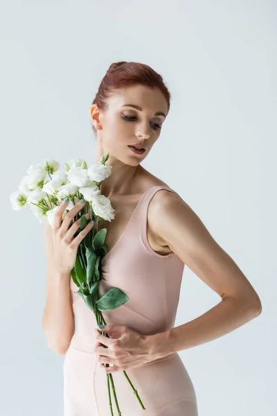 Bailarina elegante em bodysuit segurando flores isoladas em branco — Fotografia de Stock