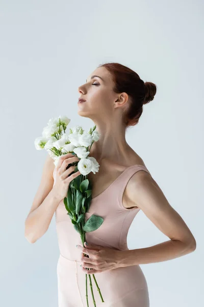 Ballerina rossa con gli occhi chiusi che tiene fiori isolati su bianco — Foto stock
