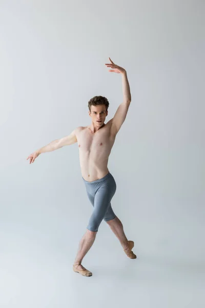 Volle Länge der eleganten Balletttänzerin, die Balletttanz isoliert auf grau vorführt — Stockfoto