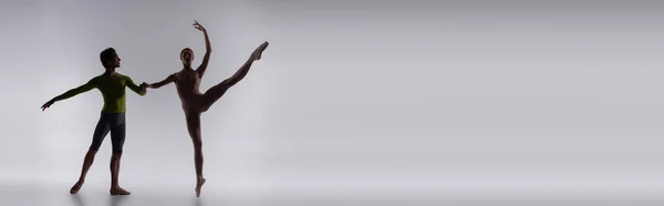 Silhouette di ballerina che si tiene per mano con ballerina su grigio, striscione — Foto stock