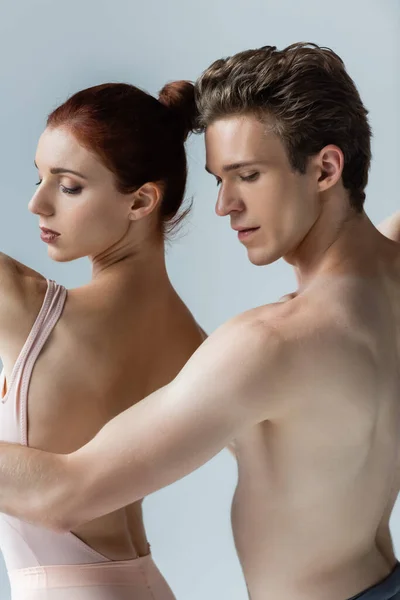 Shirtless man and redhead woman dancing ballet isolated on grey — Stock Photo