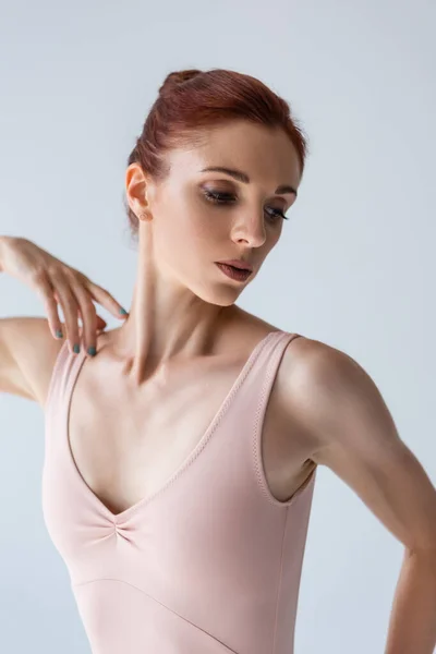 Bailarina joven y pelirroja en traje aislado en gris — Stock Photo