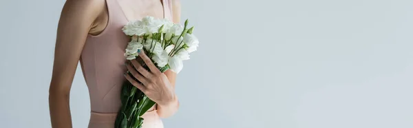 Vue recadrée de la ballerine tenant bouquet de fleurs d'eustomes isolées sur gris, bannière — Photo de stock