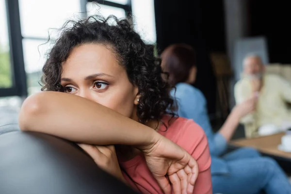Depressed lesbian african american woman near girlfriend talking to psychologist on blurred background — Stock Photo