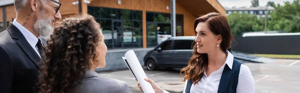 Multiethnische Geschäftspartner und Immobilienmakler in der Nähe verschwommenes Gebäude und Auto im Freien, Banner — Stockfoto