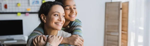 Adolescente afro-americana menina com olhos fechados abraçando mãe feliz em casa, banner — Fotografia de Stock