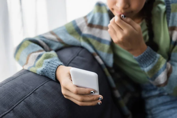 Visão cortada de adolescente afro-americano desfocado conversando no celular em casa — Fotografia de Stock