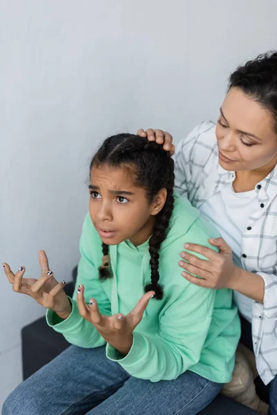 Afrikanerin beruhigt entmutigte und gestikulierende Tochter zu Hause — Stockfoto