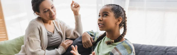 Підліток афроамериканська дівчина жестикулює під час розмови з мамою вдома, банер — стокове фото