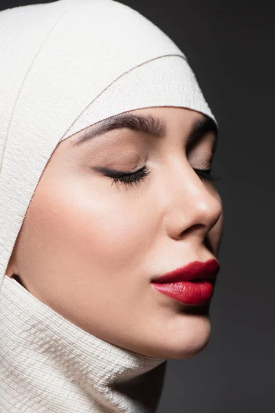 Woman with closed eyes in elastic bandage on head after plastic surgery isolated on grey — Stock Photo