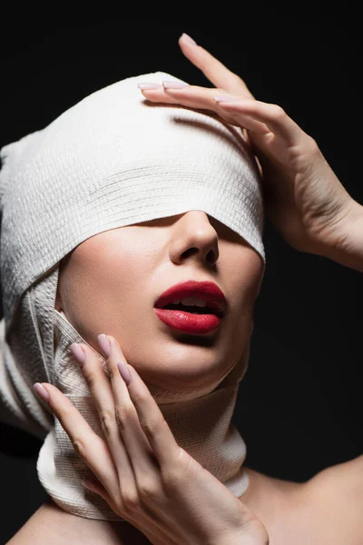 Femme en bandage élastique avec yeux couverts et bouche ouverte isolée sur gris foncé — Photo de stock